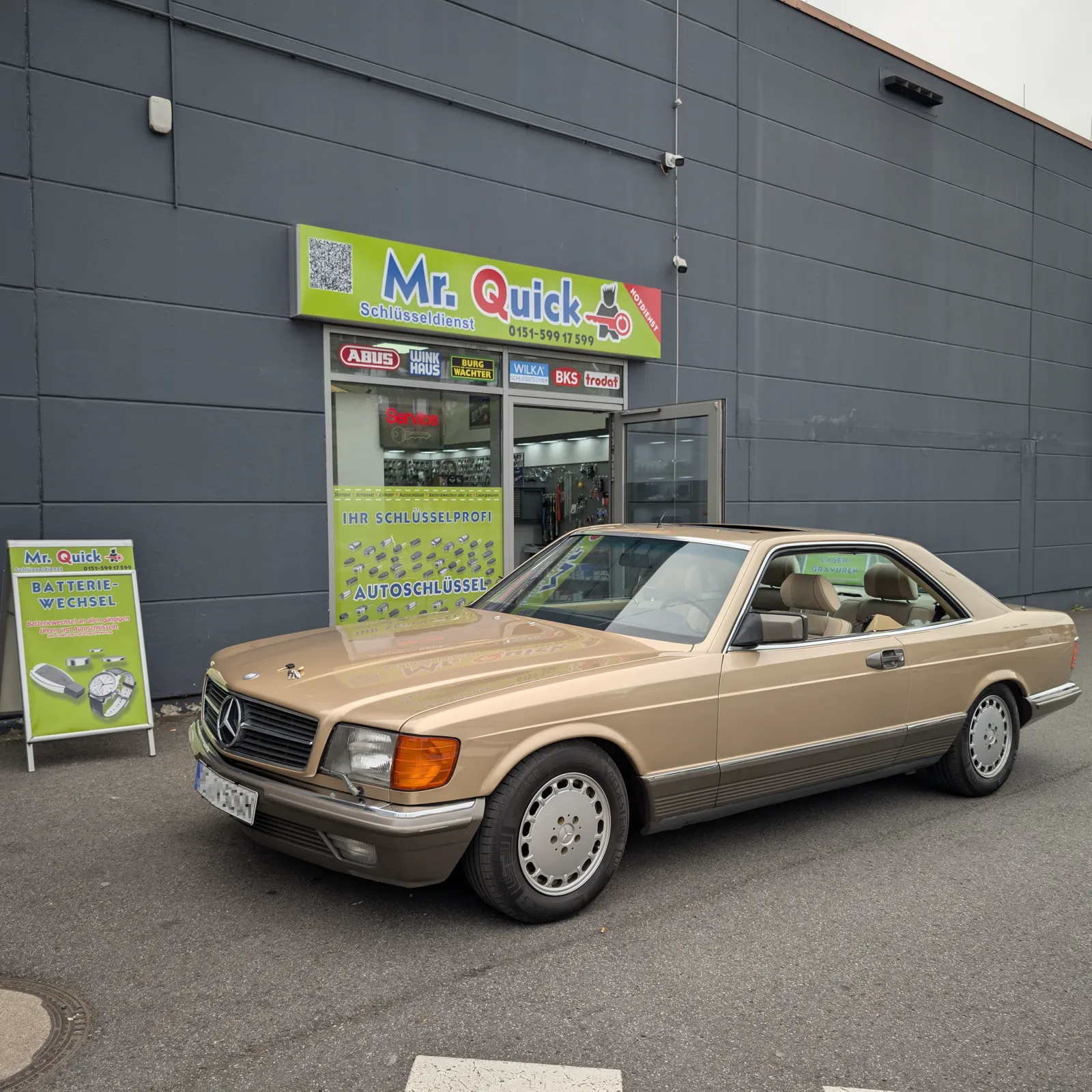 Mr. Quick Schlüsseldienst Ladengeschäft am Marktkauf Knödgen mit einem Mercedes-Oldtimer davor